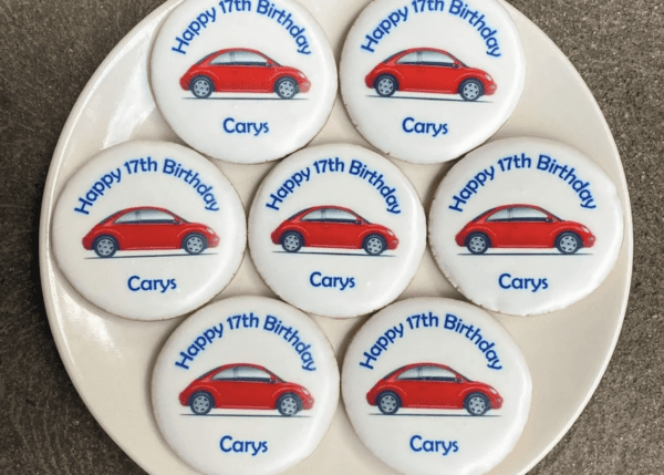 A plate with seven cookies on it that say " happy 1 7 th birthday carys ".